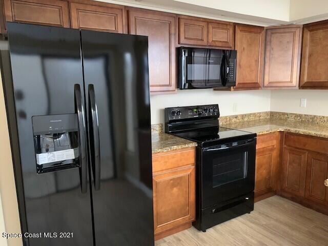 381 Myrtlewood Road Melbourne, FL 32940 - Photo 8 of 31 a kitchen with granite countertop a refrigerator stove and microwave