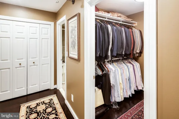 a view of walk in closet with clothes and shoes