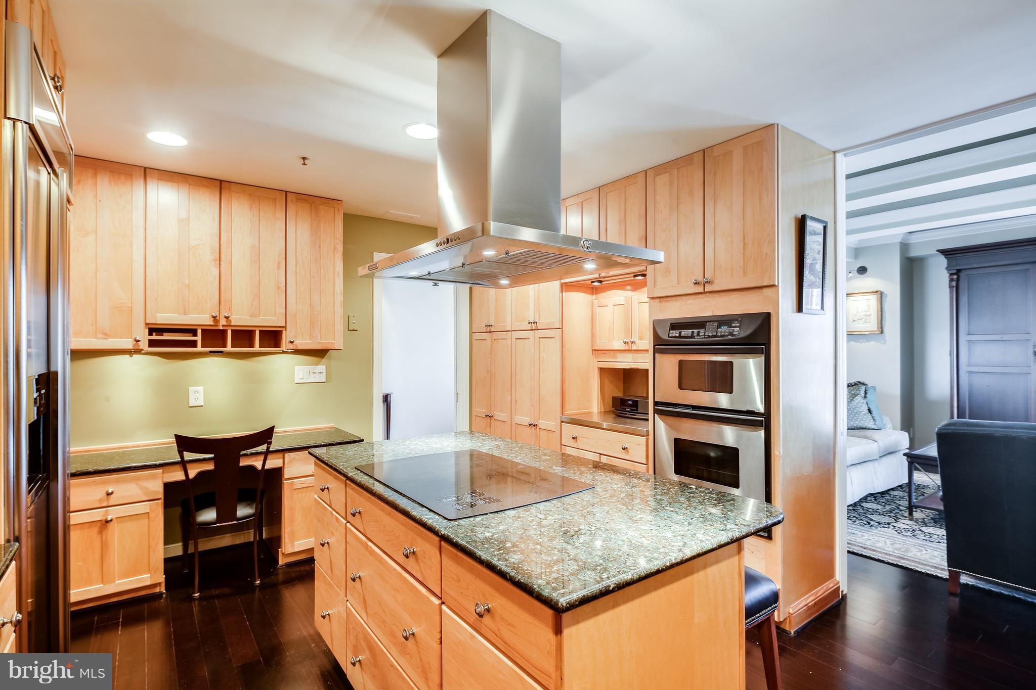 10 East Lee Street, Unit 1802 Baltimore, MD 21202 - Photo 8 of 21 a kitchen with stainless steel appliances granite countertop a sink a stove and a wooden floors