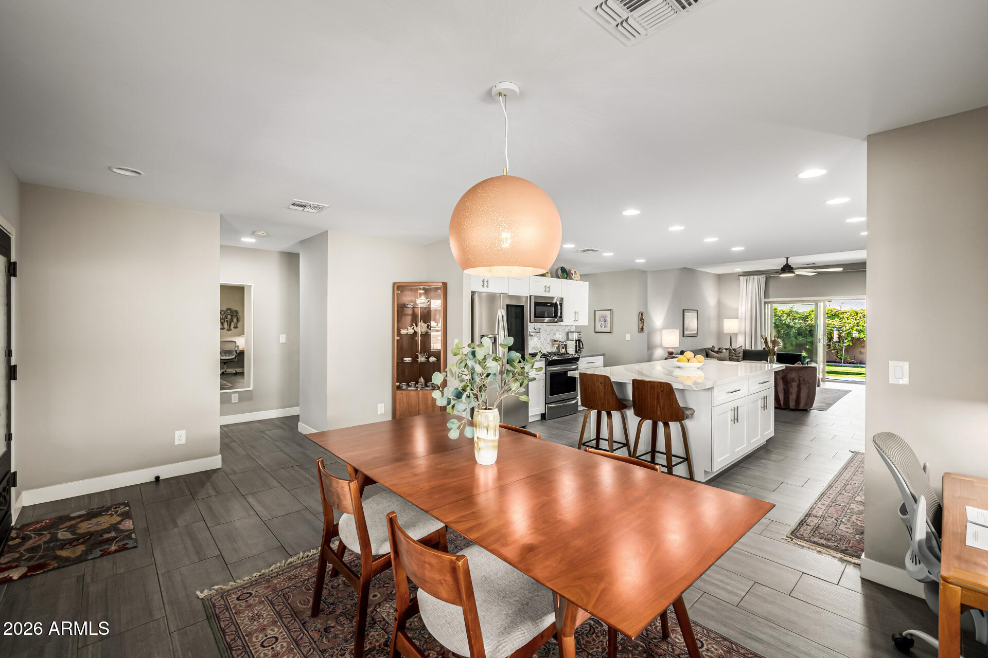 6726 North 11th Street Phoenix, AZ 85014 - Photo 12 of 49 a dining room with wooden floor a chandelier a wooden table and chairs