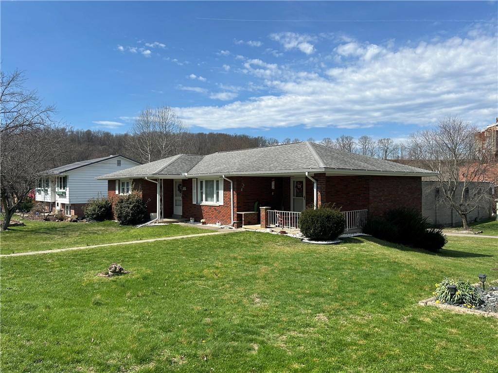 a view of a house with a yard and sitting area