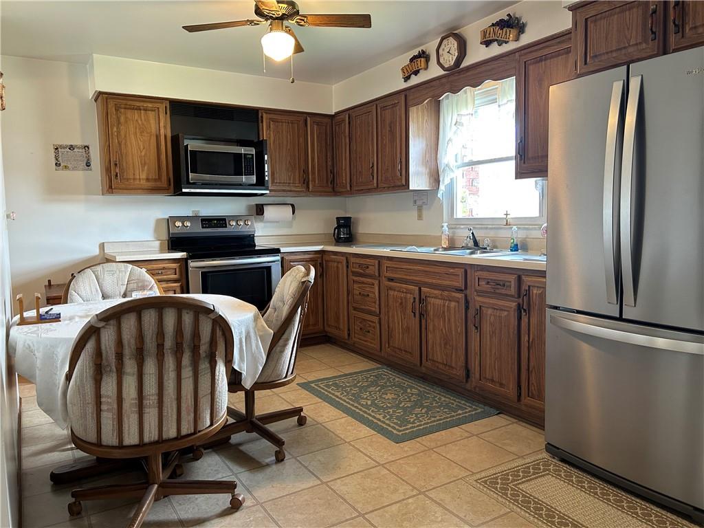 356 3rd Street Smithton, PA 15479 - Photo 10 of 21 a kitchen with stainless steel appliances granite countertop a sink a stove a refrigerator cabinets a dining table and chairs