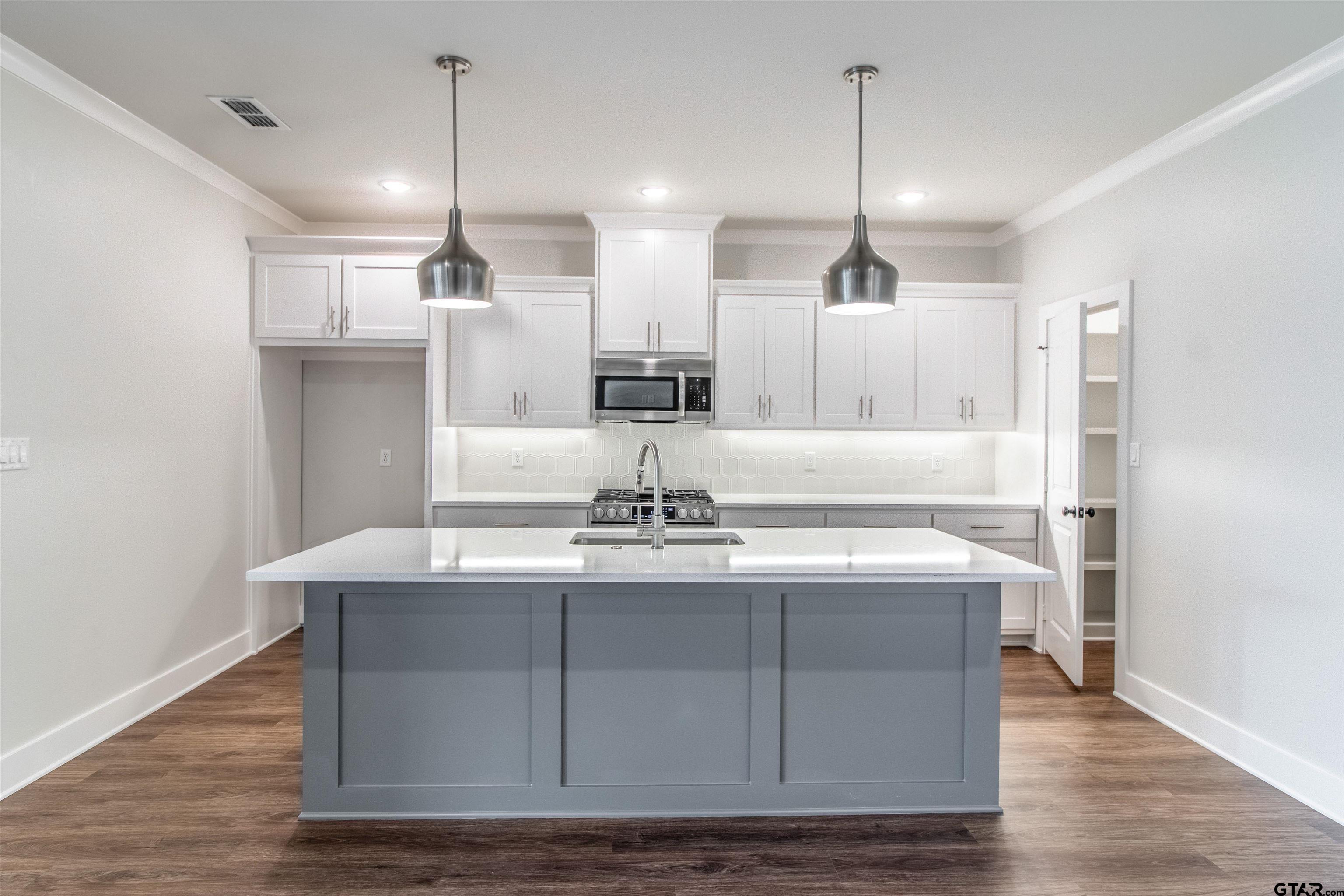 7013 Hillside Avenue Tyler, TX 75707 - Photo 15 of 37 a kitchen with kitchen island a sink counter top space and stainless steel appliances