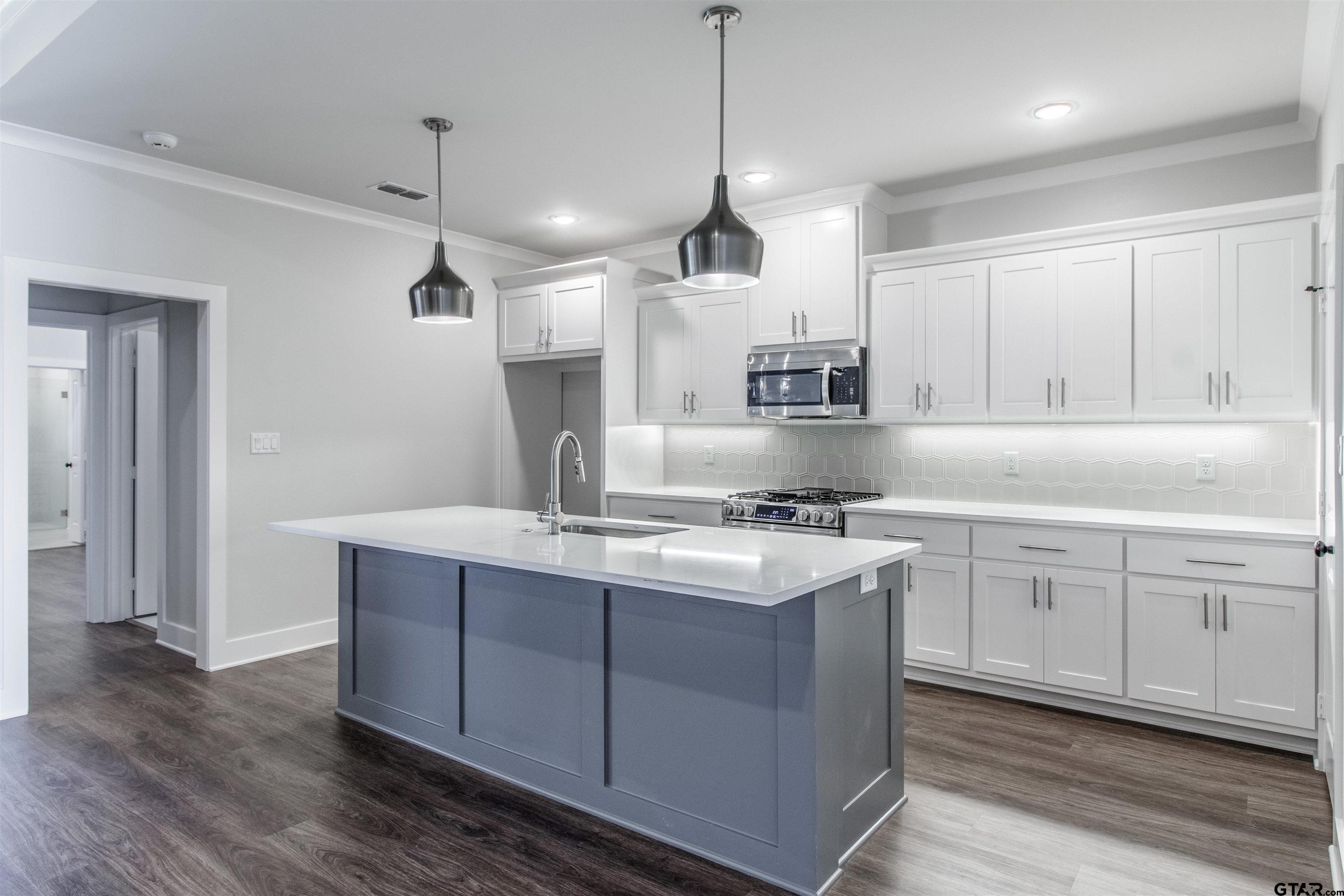 7013 Hillside Avenue Tyler, TX 75707 - Photo 16 of 37 a kitchen with stainless steel appliances granite countertop a sink a stove a refrigerator and island with wooden floor