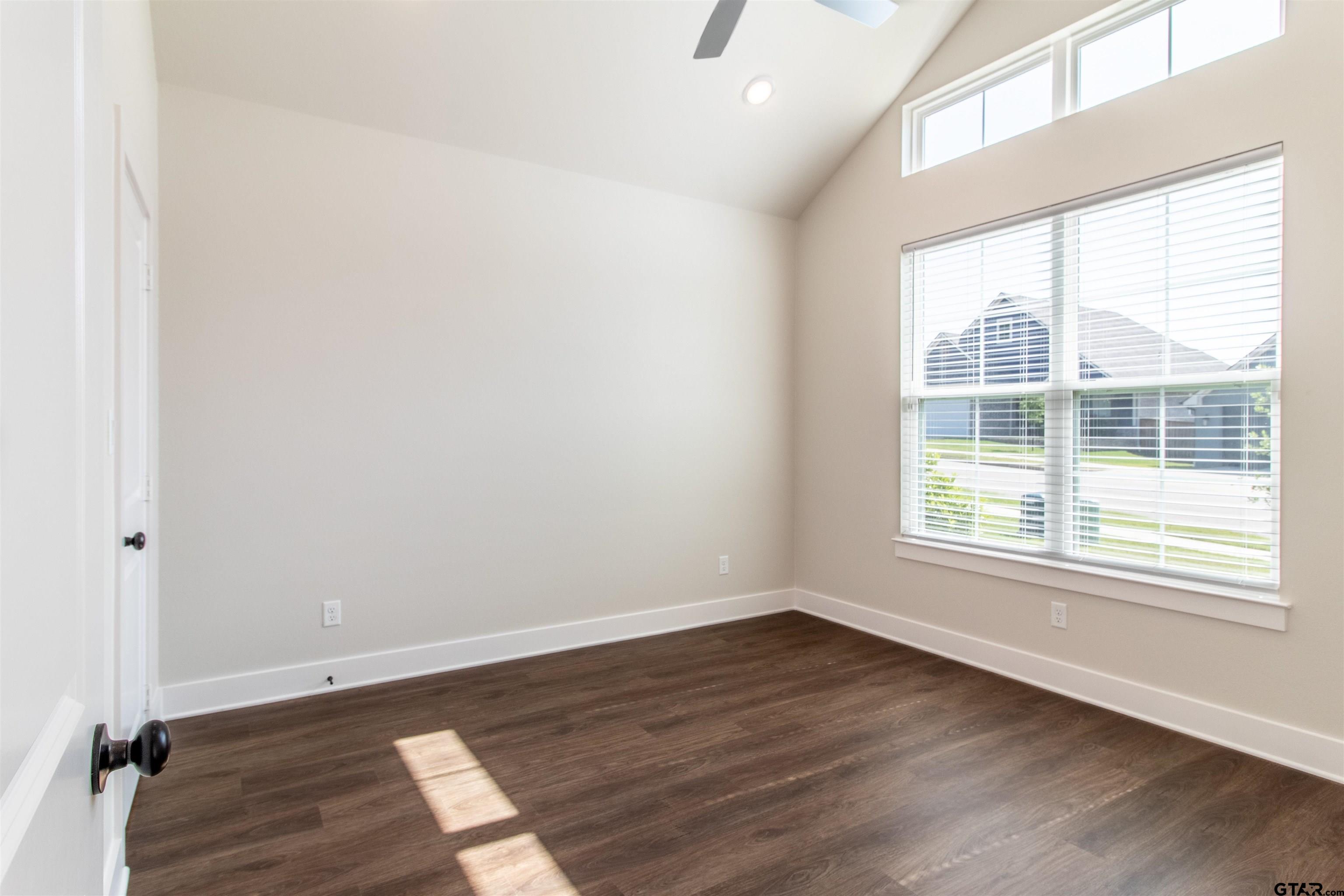7013 Hillside Avenue Tyler, TX 75707 - Photo 5 of 37 an empty room with wooden floor and windows
