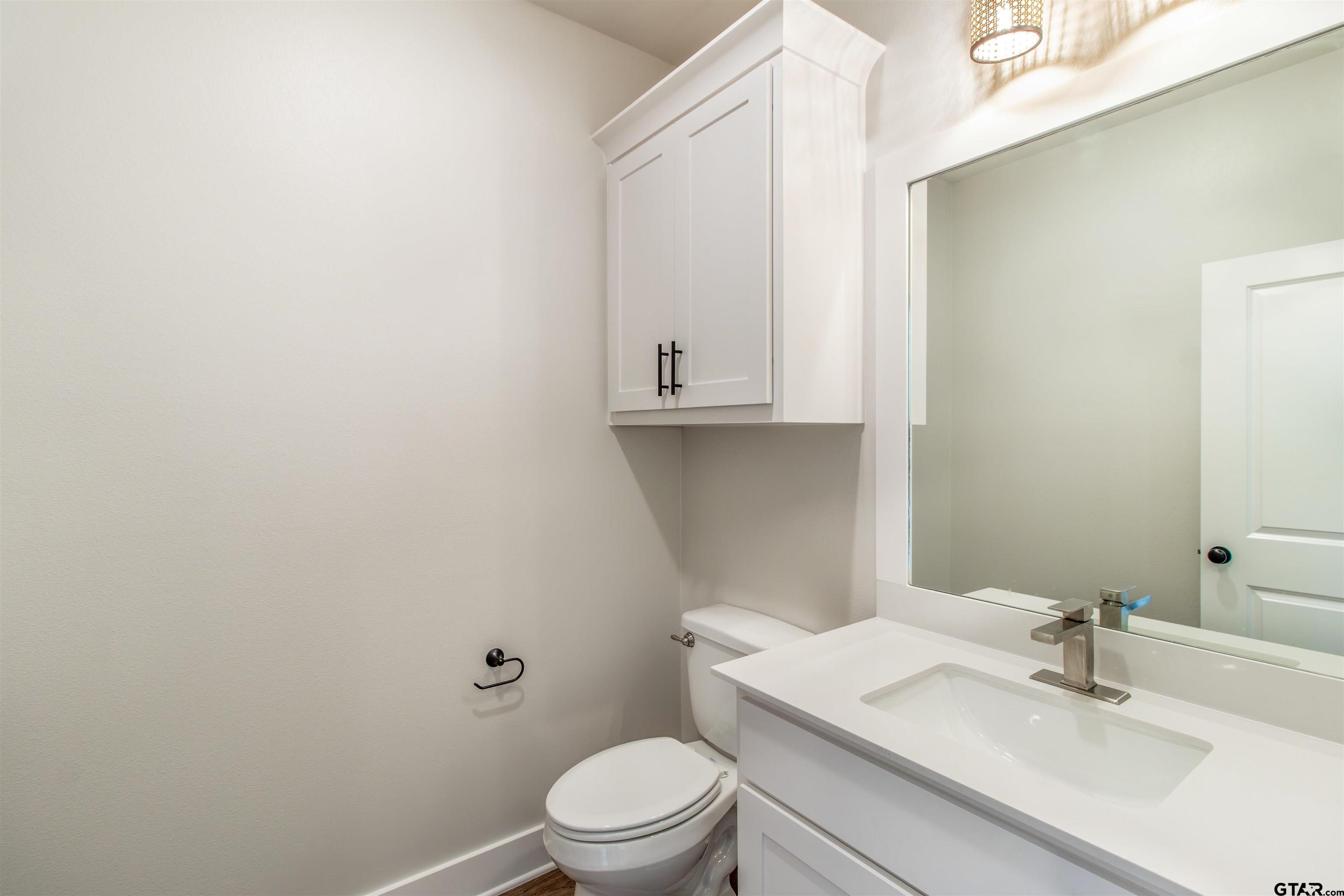 7013 Hillside Avenue Tyler, TX 75707 - Photo 7 of 37 a bathroom with a sink a toilet and mirror