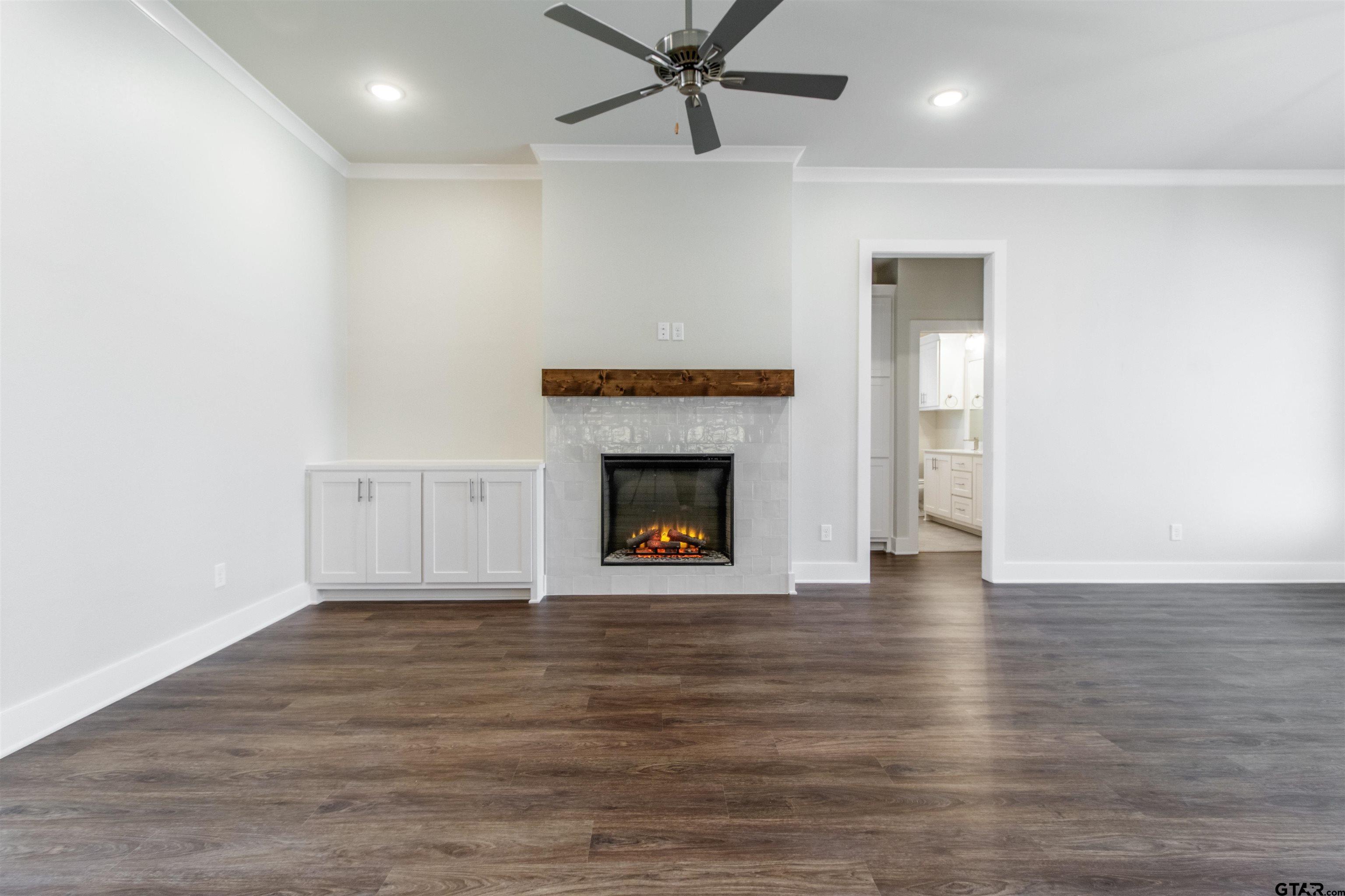 7013 Hillside Avenue Tyler, TX 75707 - Photo 8 of 37 a view of an empty room with wooden floor fireplace and a window