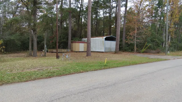 a front view of a house with a yard and tree s