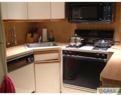 197 Evergreen Road, Unit 7B Edison, NJ 08837 - Photo 3 of 6 a kitchen with a stove and a microwave
