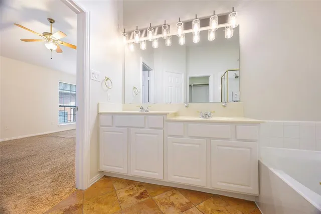a bathroom with a sink vanity tub and a mirror