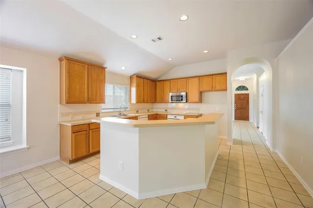 a large white kitchen with a stove a sink dishwasher and a refrigerator