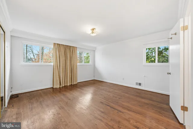 an empty room with windows and closet