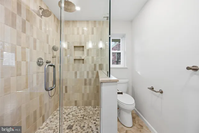 a bathroom with a granite countertop shower a toilet and a sink