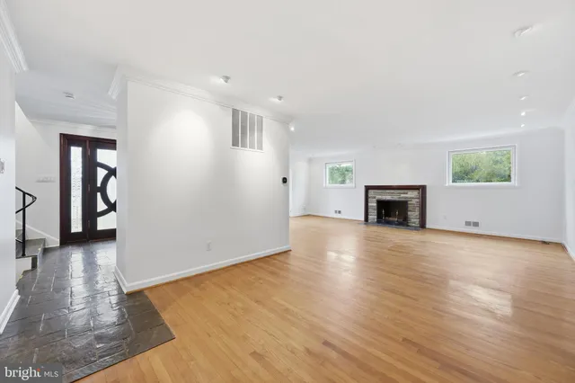 a view of empty room with wooden floor and fireplace