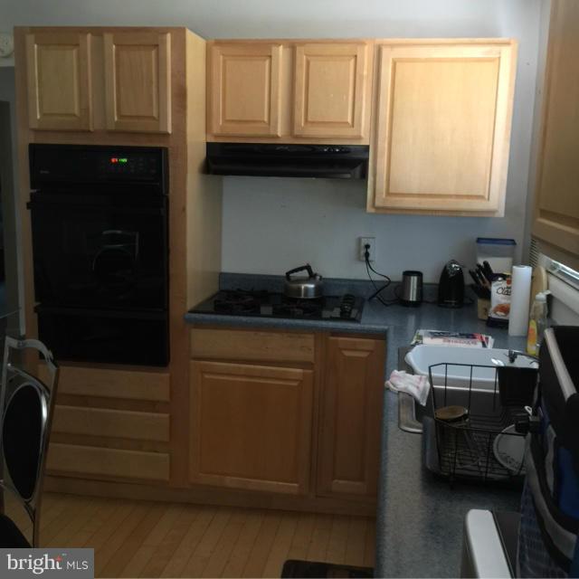 6224 Auth Road Suitland, MD 20746 - Photo 12 of 14 a kitchen with granite countertop cabinets and black appliances