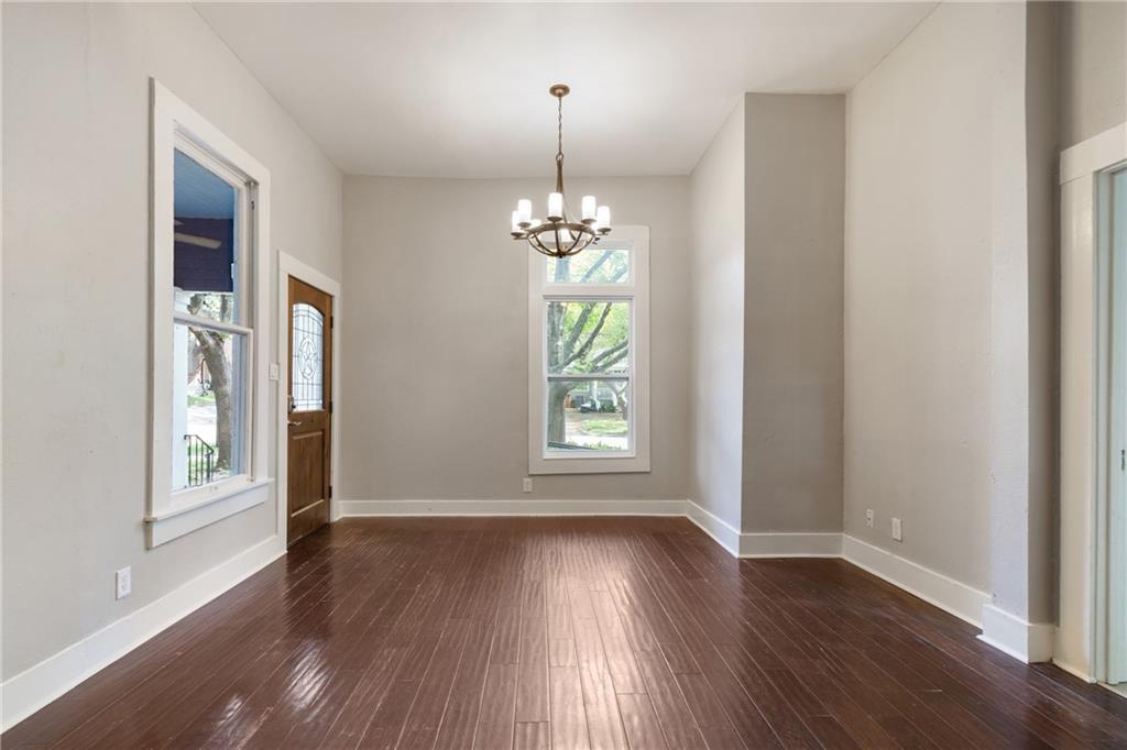 3210 Hampton Road, Unit A B C Austin, TX 78705 - Photo 40 of 42 Spacious interior room featuring wood-finish flooring, light-toned walls, and a chandelier