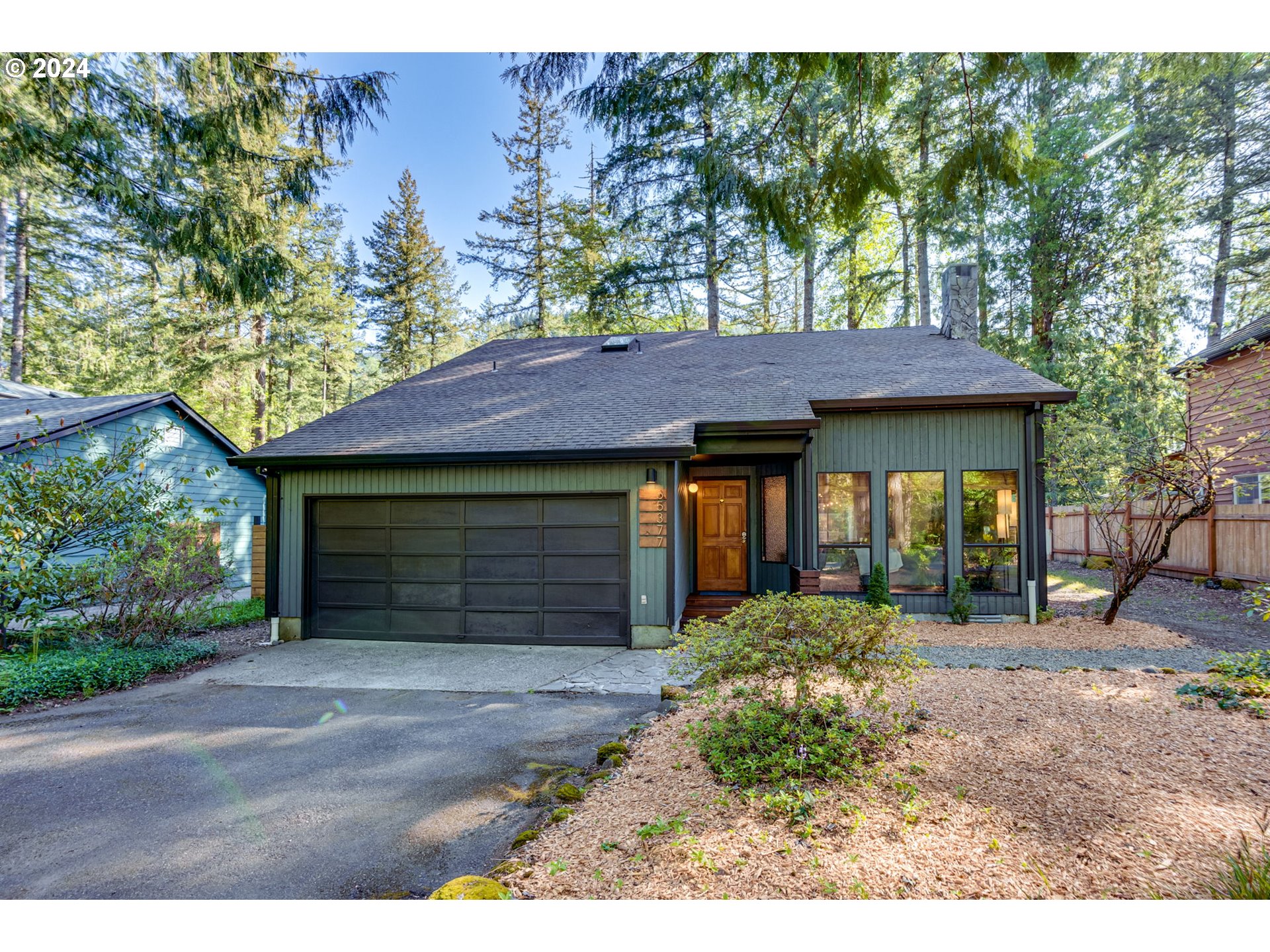 65377 East Sandy River Lane Rhododendron, OR 97049 - Photo 1 of 40 a front view of a house with a garden