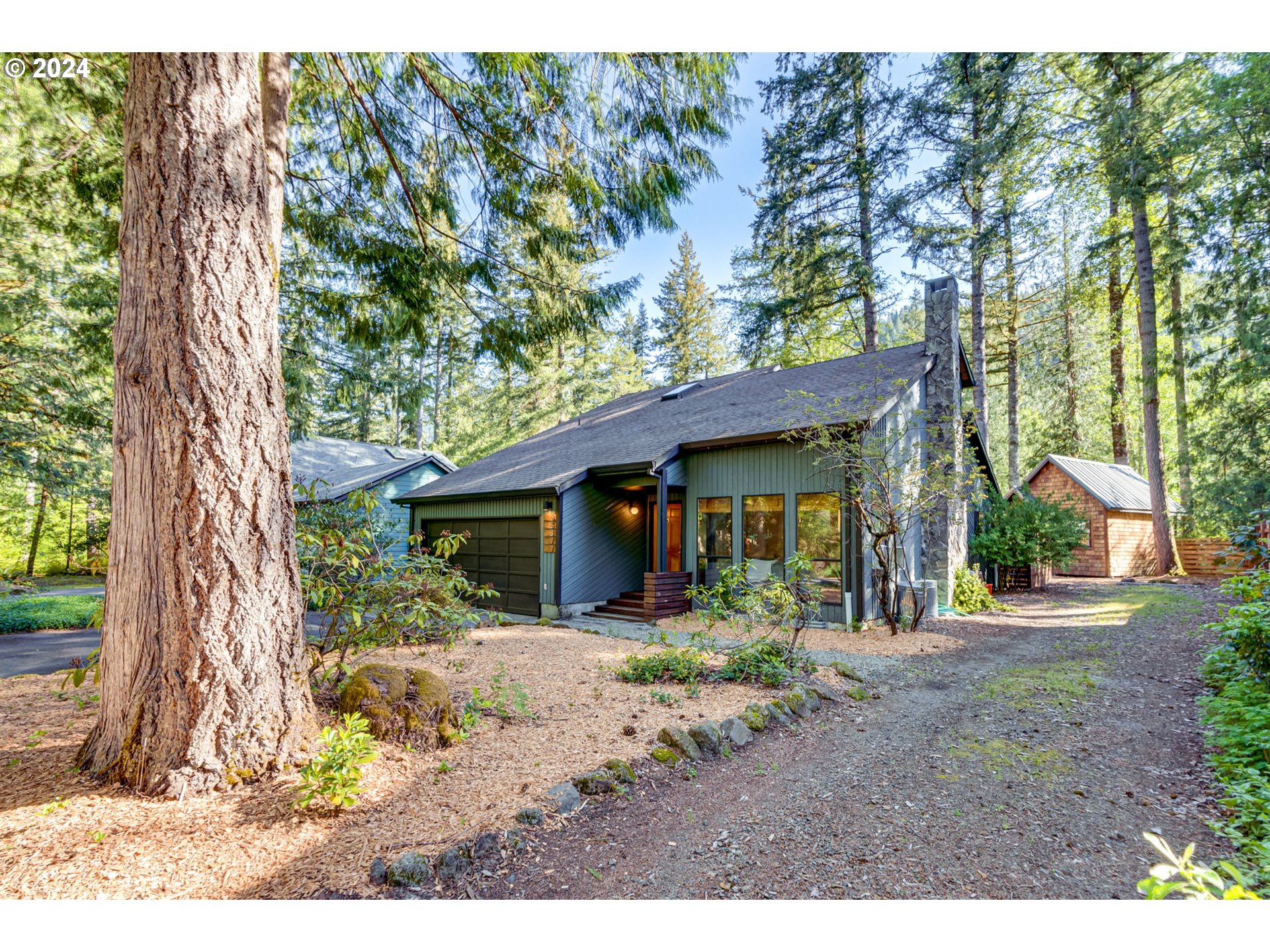 65377 East Sandy River Lane Rhododendron, OR 97049 - Photo 2 of 40 a front view of a house with a porch