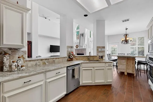 a kitchen with white cabinets sink and stove