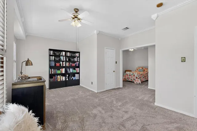 a bedroom with furniture and a chandelier fan