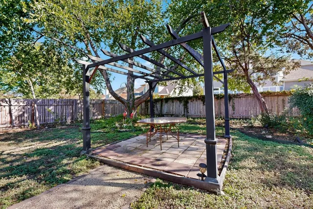 a view of a yard with a tree and a fence