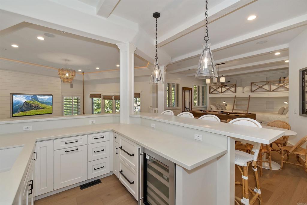27567 West Shore Road Lake Arrowhead, CA 92352 - Photo 22 of 62 a large kitchen with kitchen island a stove a sink a dining table and chairs with wooden floor