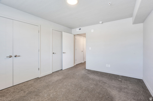 572 South 100 West, Unit E210 Springville, UT 84663 - Photo 26 of 35 Neutral gray carpeting complementing light gray wall tones, recessed ceiling lighting, and multiple white panel doors with brushed nickel hardware