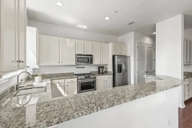 a kitchen with stainless steel appliances granite countertop a sink stove and refrigerator