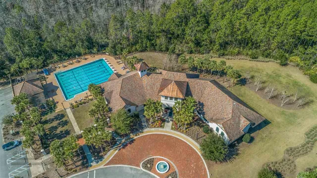 an aerial view of a house with outdoor space and trees all around