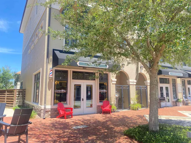 a view of a brick house with a large windows and a large tree