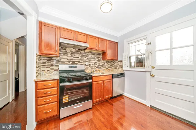 a kitchen with wooden cabinets and a stove top oven