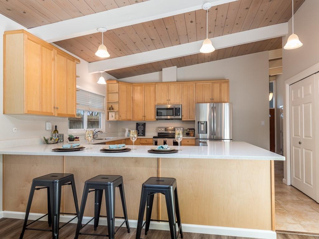 3410 Hillcrest Drive Belmont, CA 94002 - Photo 9 of 26 a kitchen with stainless steel appliances kitchen island granite countertop a table chairs sink and cabinets