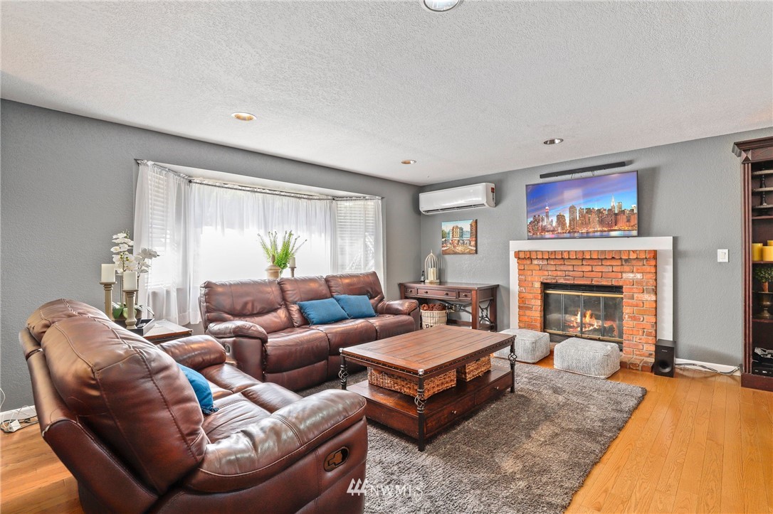 1417 234th Street Southwest Bothell, WA 98021 - Photo 3 of 40 a living room with furniture a fireplace and a large window