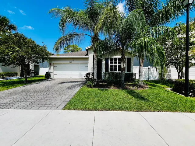 a view of house with a yard and palm trees