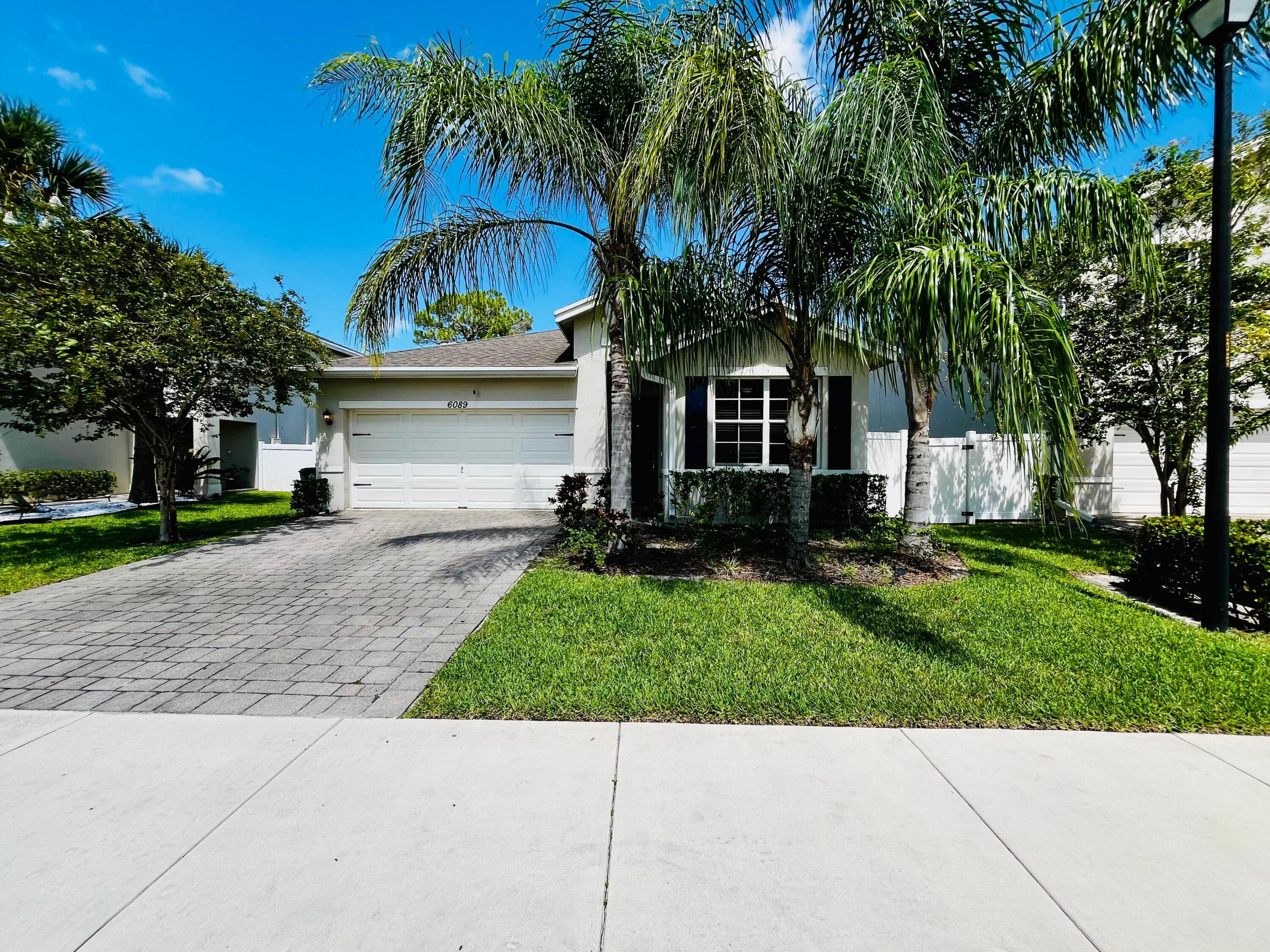 a view of house with a yard and palm trees