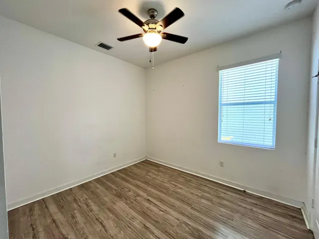 an empty room with a window and a fan