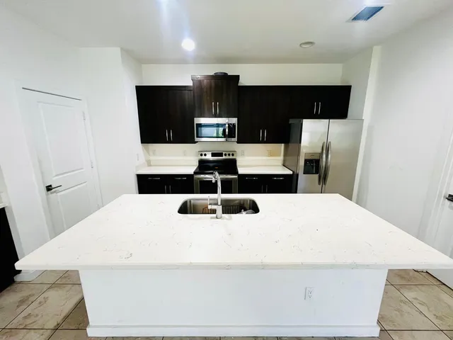 a large white bed in a small kitchen
