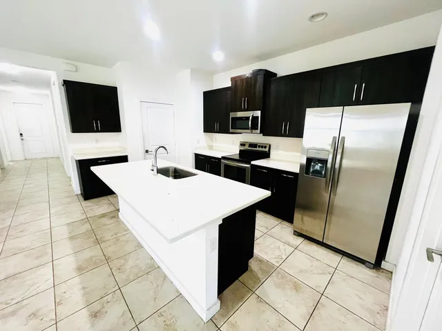a kitchen with stainless steel appliances a refrigerator sink and microwave
