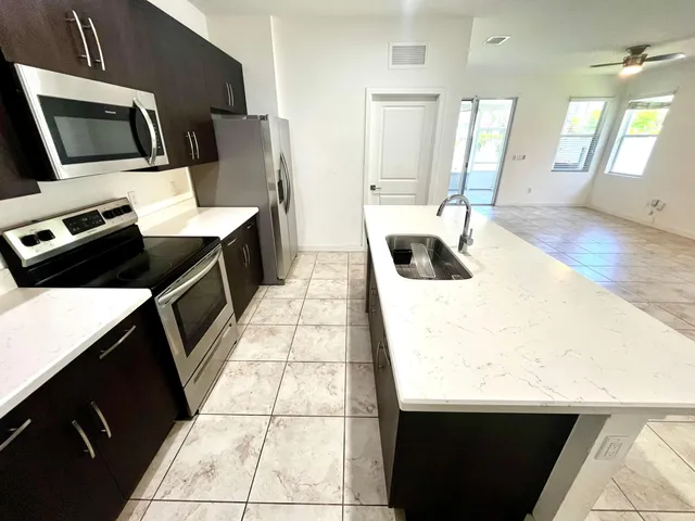 a kitchen with a sink a stove top oven a counter space and cabinets