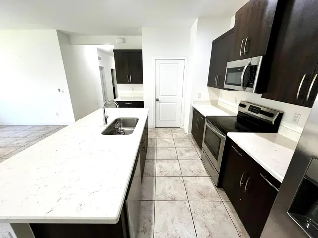 a kitchen with stainless steel appliances a stove microwave and sink