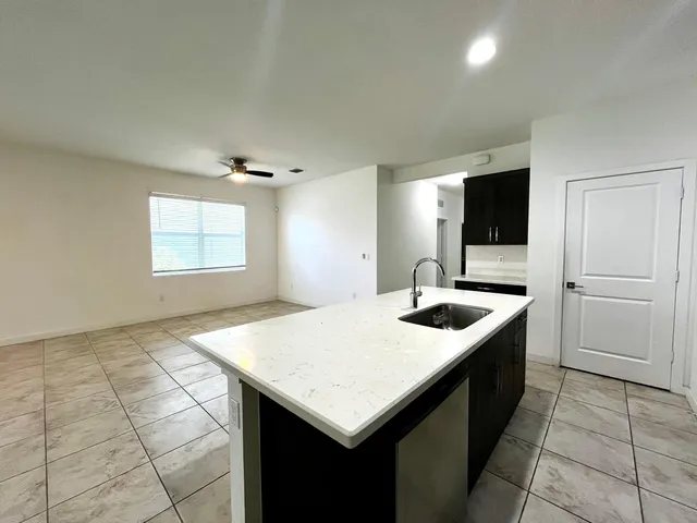 a kitchen with a sink a counter space and a refrigerator