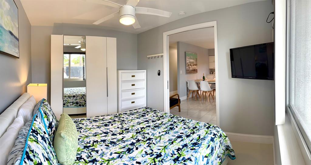 1705 North Riverside Drive, Unit 2 Pompano Beach, FL 33062 - Photo 23 of 60 a bedroom with a bed and a flat tv screen on dresser