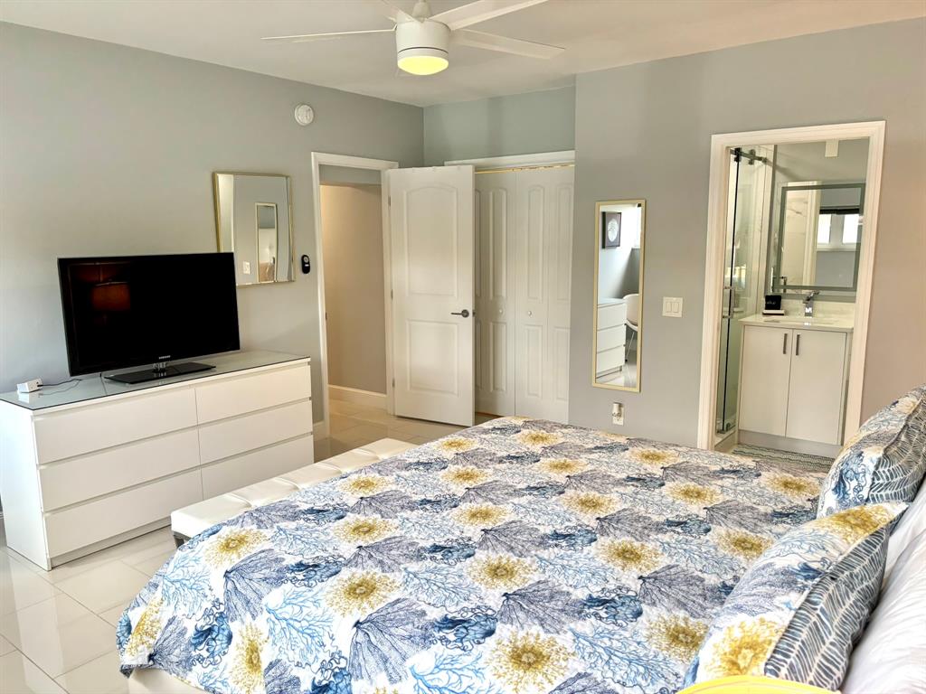 1705 North Riverside Drive, Unit 2 Pompano Beach, FL 33062 - Photo 31 of 60 a bedroom with a bed and a flat screen tv in kitchen