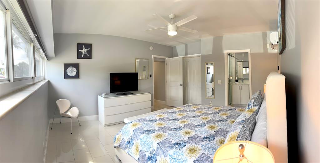 1705 North Riverside Drive, Unit 2 Pompano Beach, FL 33062 - Photo 32 of 60 a spacious bedroom with a bed and a flat screen tv