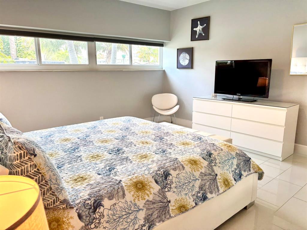 1705 North Riverside Drive, Unit 2 Pompano Beach, FL 33062 - Photo 33 of 60 a bedroom with a bed and a flat screen tv