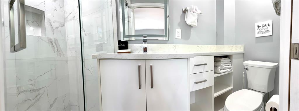 1705 North Riverside Drive, Unit 2 Pompano Beach, FL 33062 - Photo 39 of 60 a bathroom with a granite countertop toilet sink and mirror