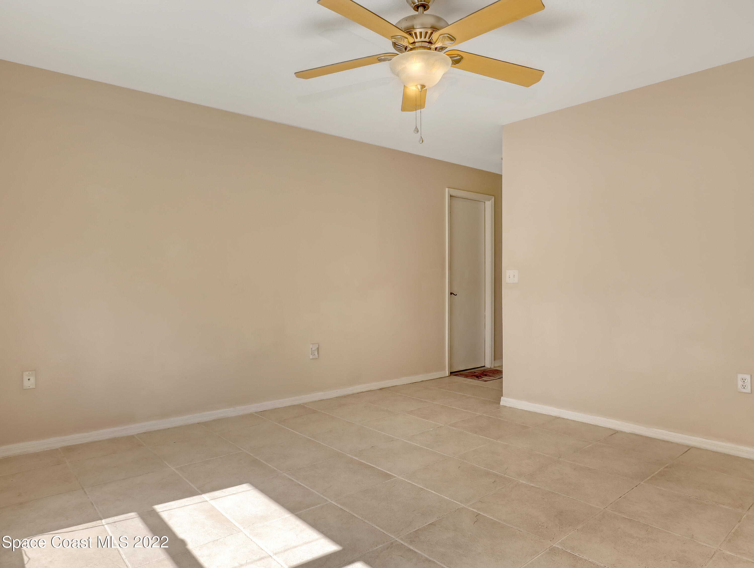 4764 Doreen Road Cocoa, FL 32927 - Photo 11 of 54 an empty room with a chandelier fan and windows