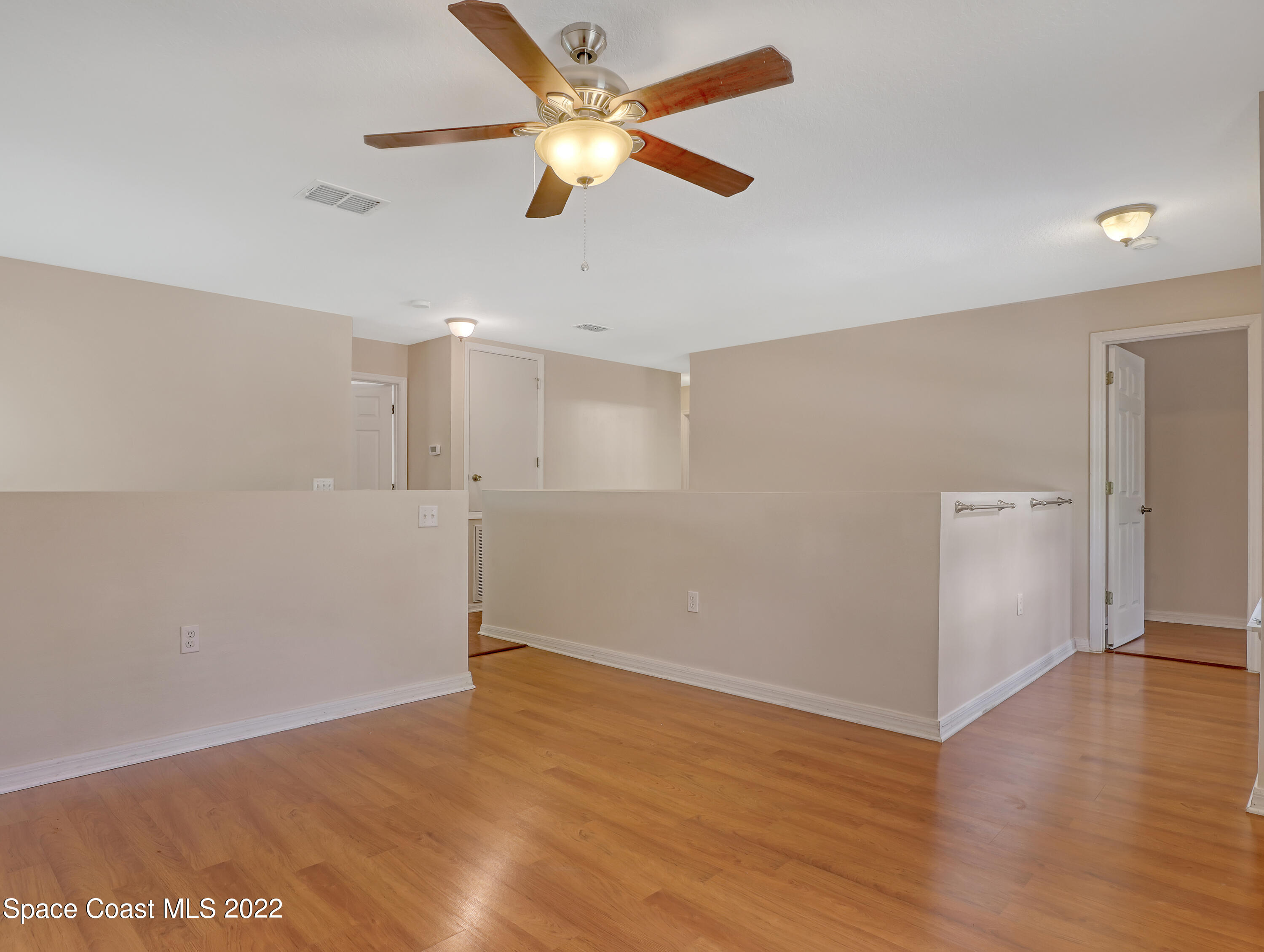 4764 Doreen Road Cocoa, FL 32927 - Photo 22 of 54 an empty room with wooden floor ceiling fan and window