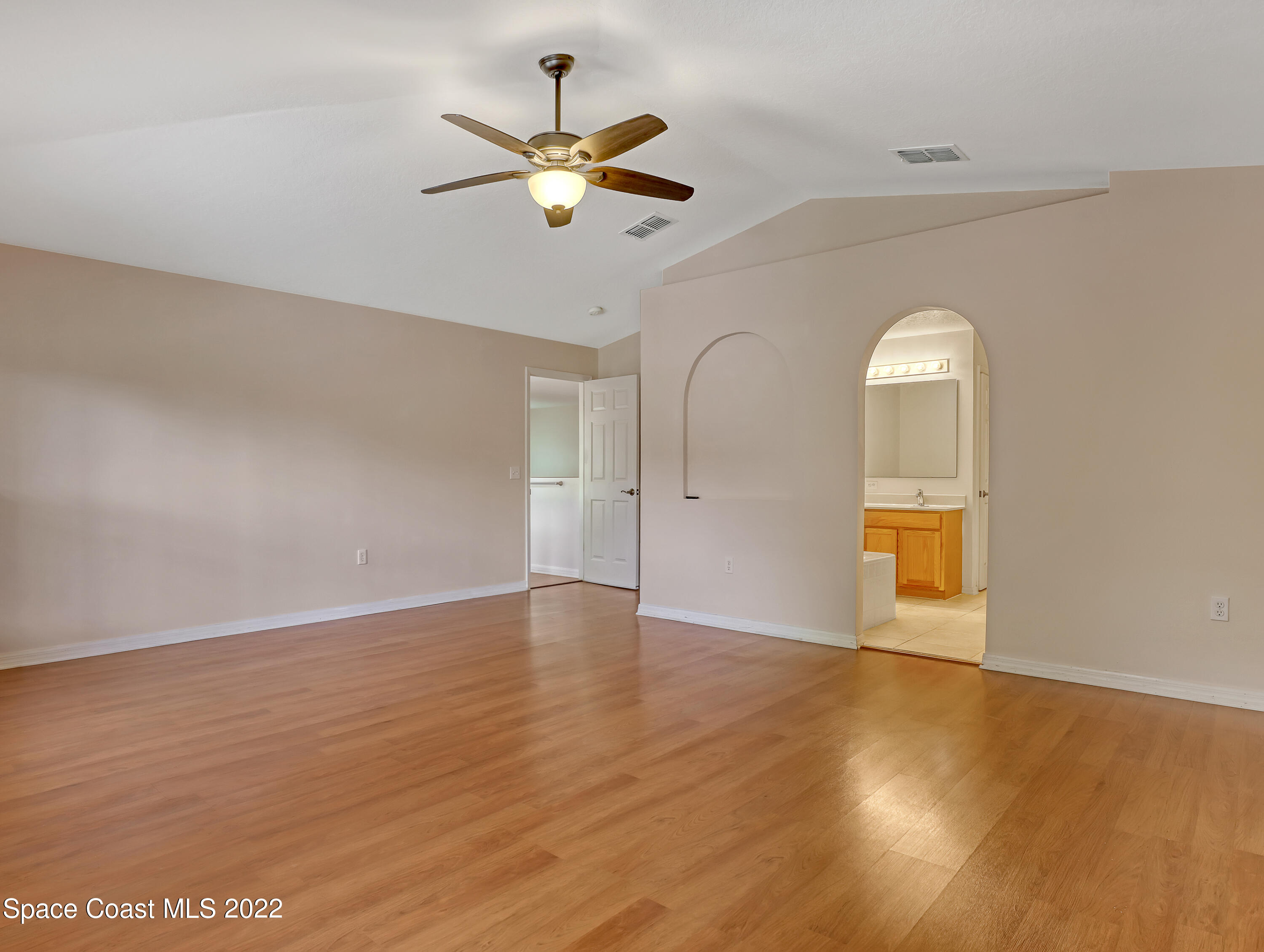4764 Doreen Road Cocoa, FL 32927 - Photo 24 of 54 an empty room with wooden floor chandelier fan and windows