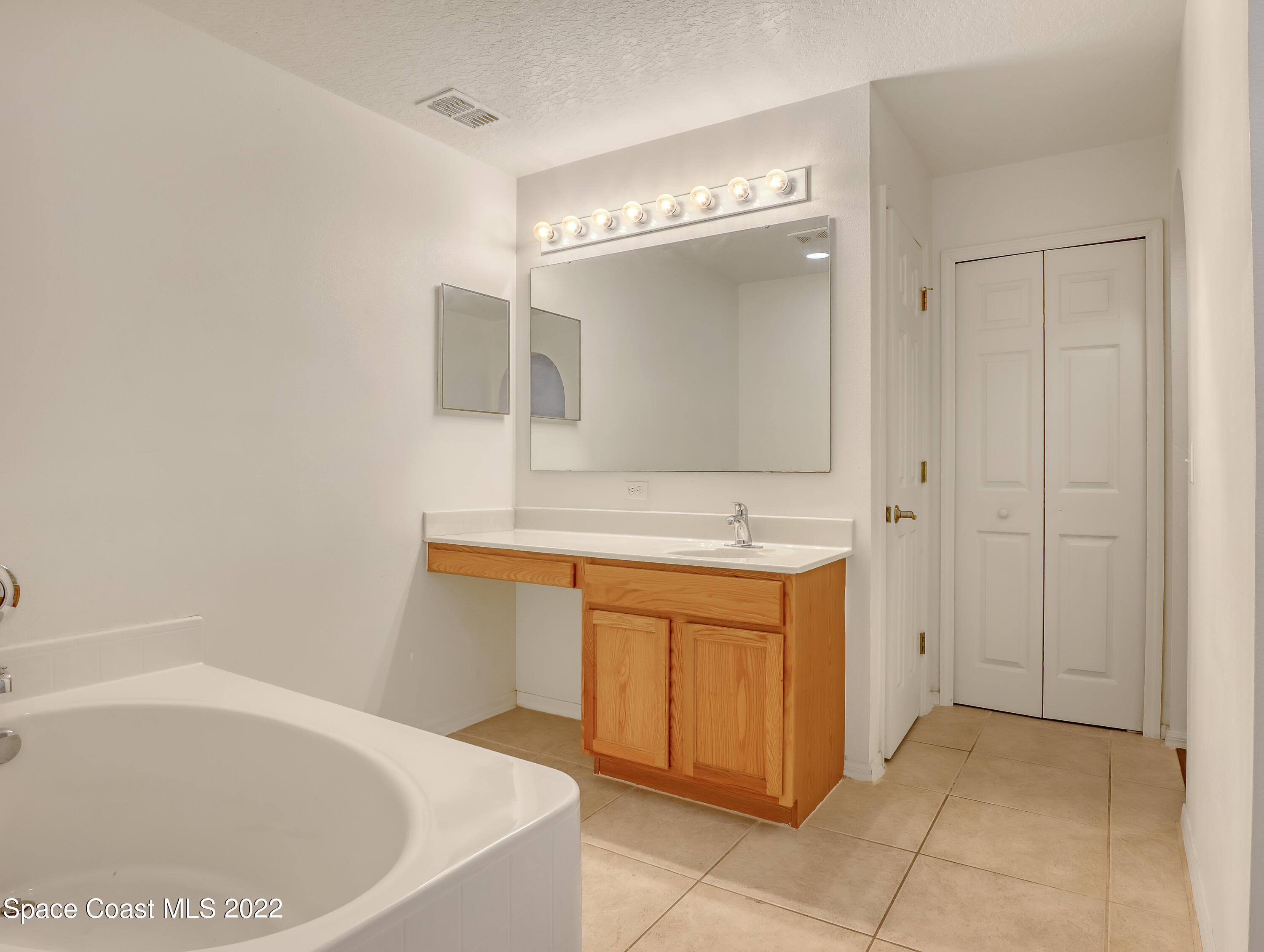 4764 Doreen Road Cocoa, FL 32927 - Photo 25 of 54 a spacious bathroom with a tub sink and mirror
